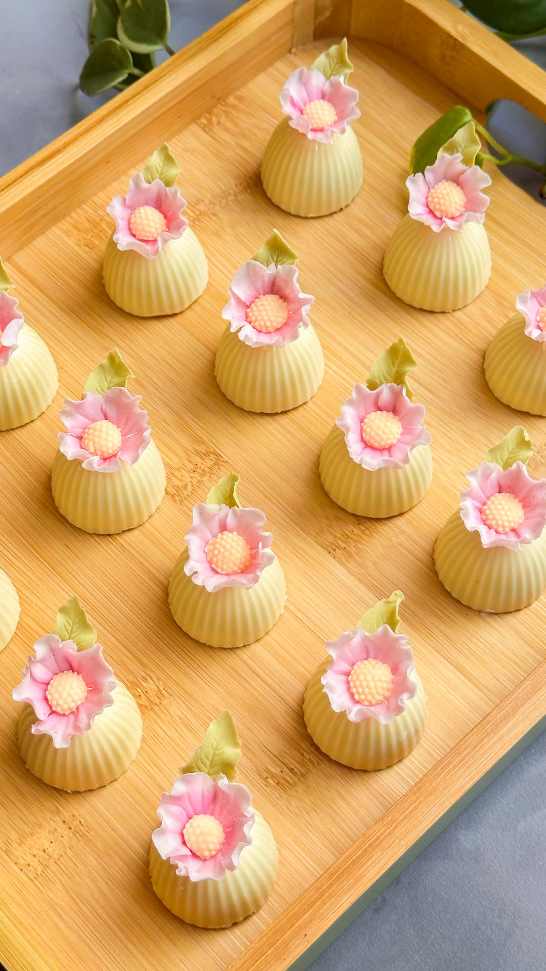 Brigadeiros com mini flores de açúcar em bandeja de madeira